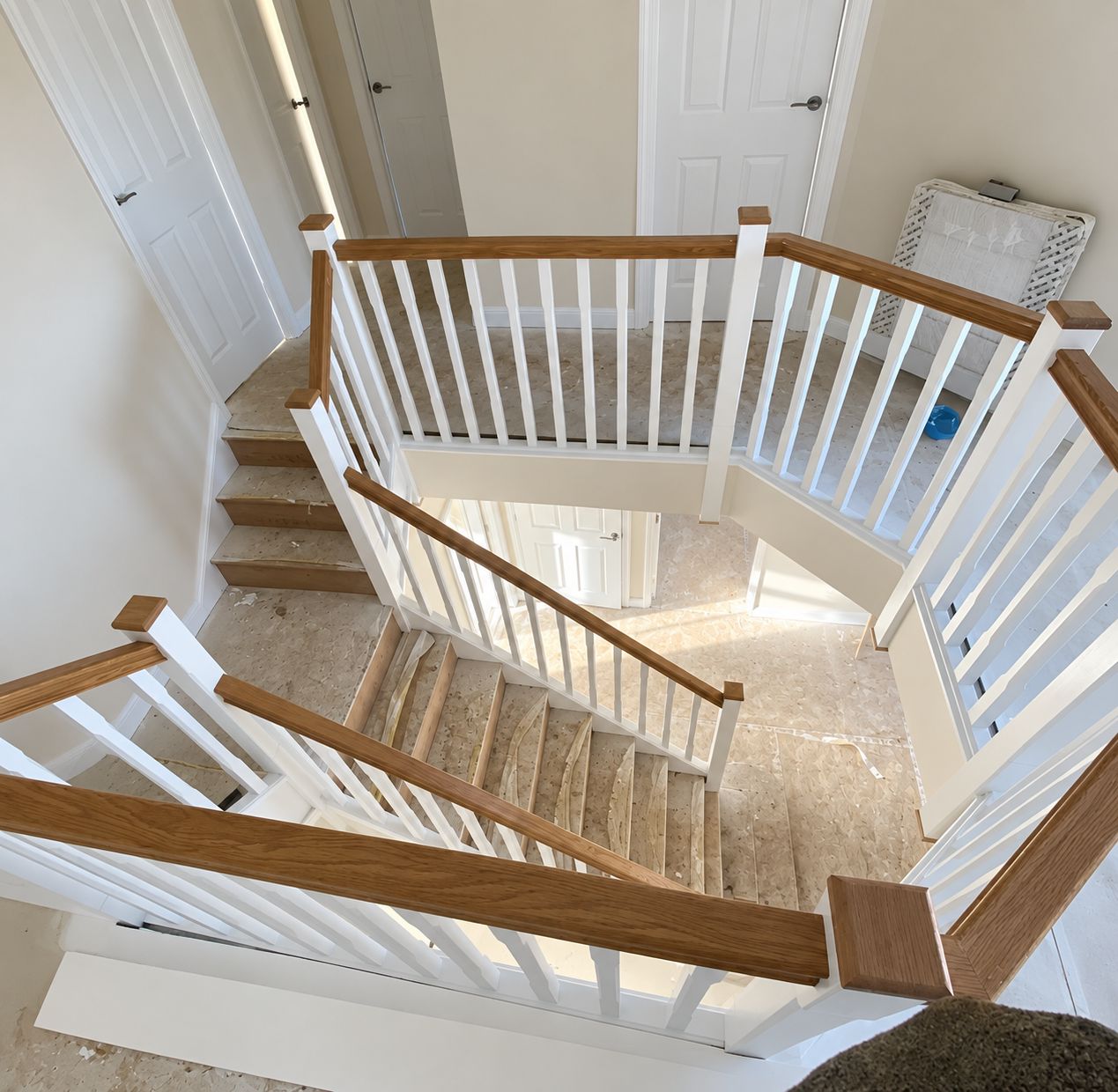 Galleried landing staircase with white spindles and oak handrails in Leicester