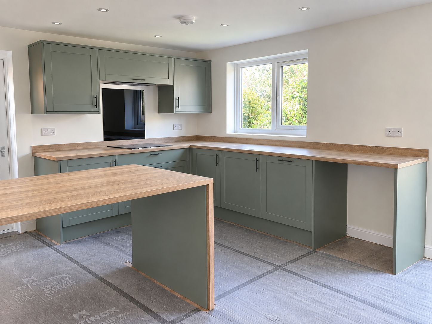 Sage green shaker kitchen with oak worktops and island fitted in Leicester