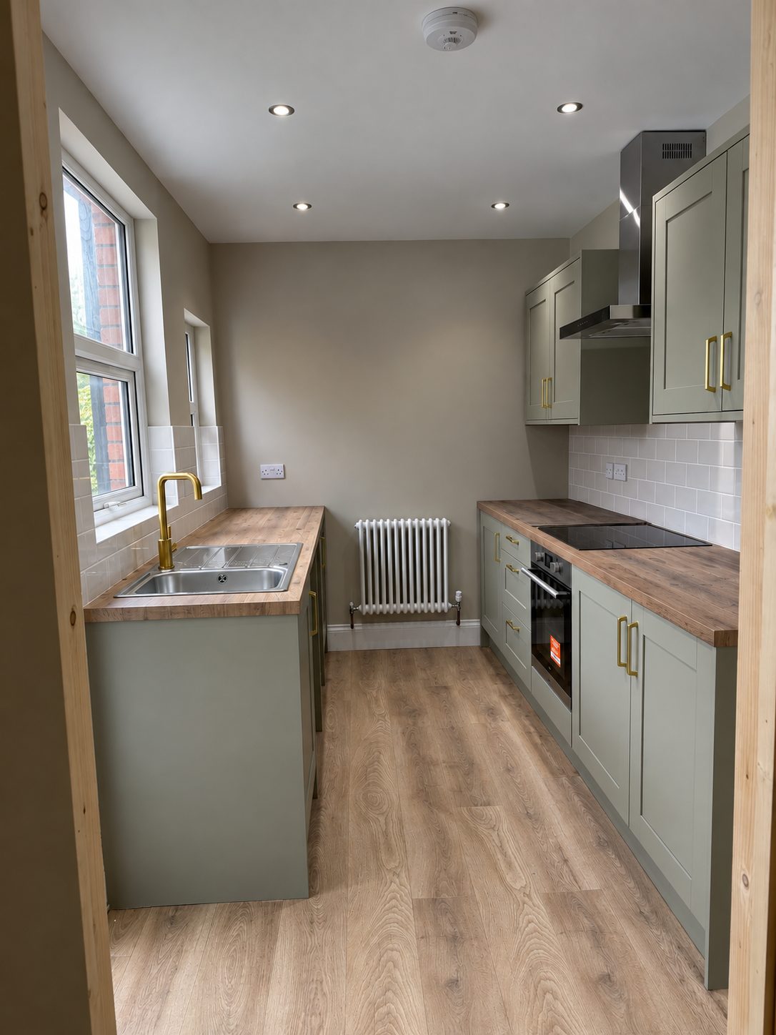 Sage green shaker kitchen with wood worktops and brass fittings fitted in Leicester